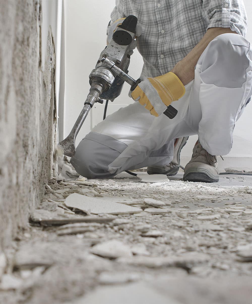 Travaux de démolition pour rénovation – Groupe Logéos Haut-Rhin Ouvrier utilisant un marteau-piqueur pour démolition dans le cadre d’un chantier de rénovation par le Groupe Logéos