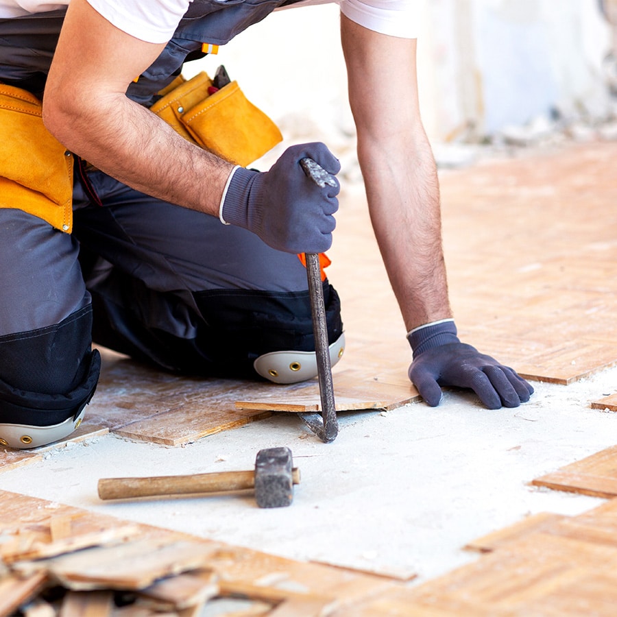 Travaux de rénovation et dépose de revêtement – Groupe Logéos Haut-Rhin Ouvrier du Groupe Logéos effectuant des travaux de rénovation, dépose d’ancien revêtement de sol